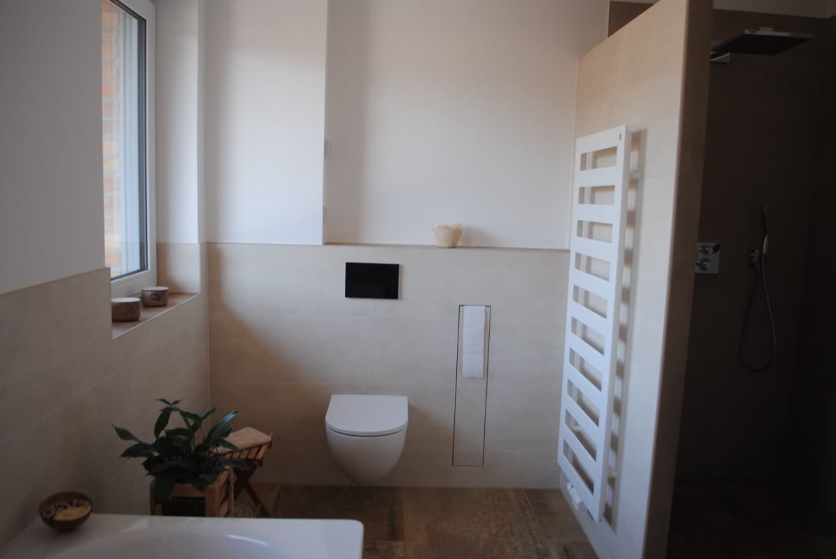 Modernes Bad mit wandhängendem WC und Wandheizkörper in Weiß