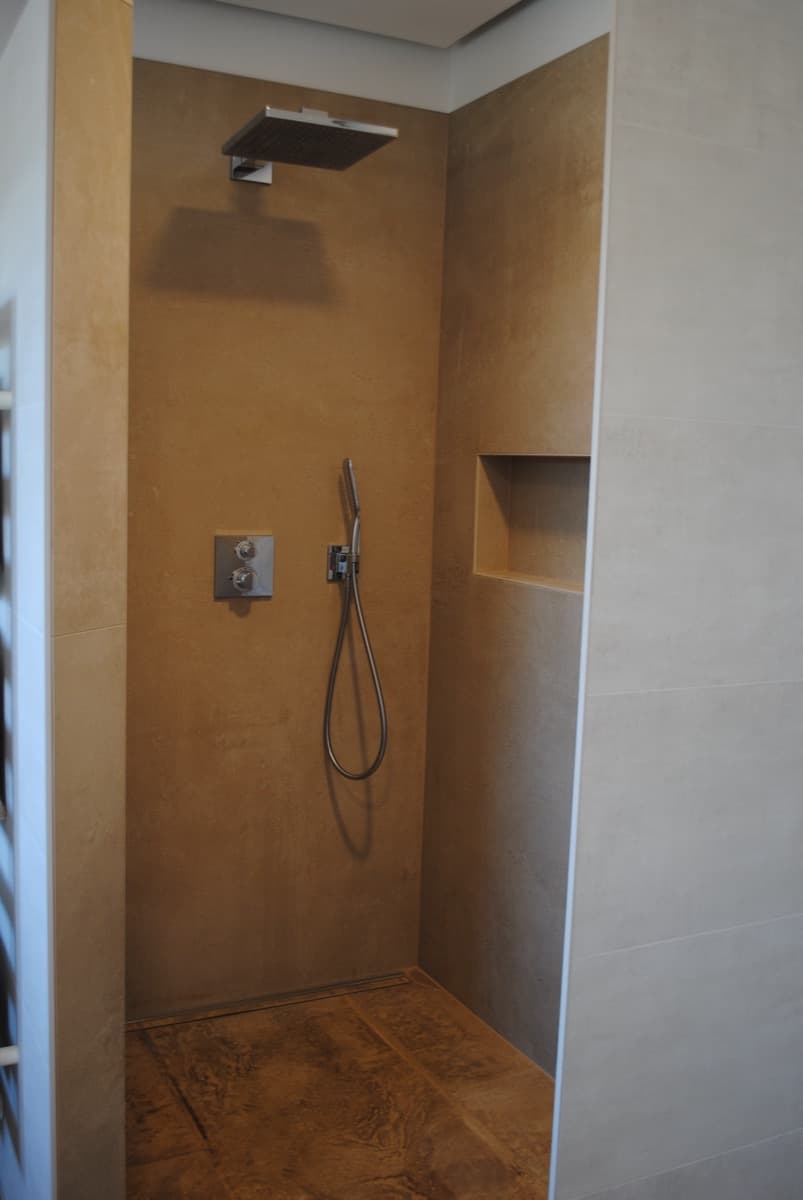 Badezimmer mit wandhängendem WC und befliestem Rollenhalter